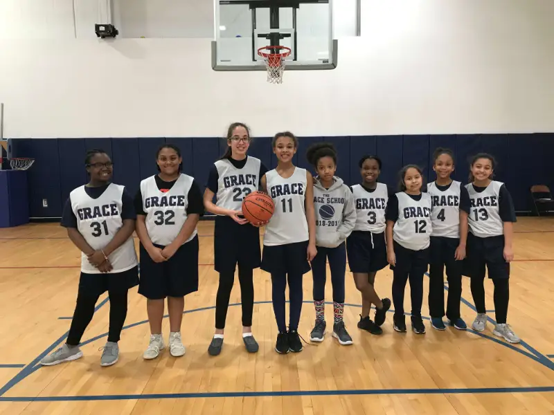 girls basketball team posing on the court