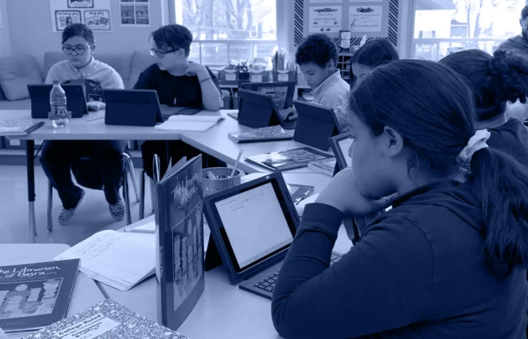 Kids studying on tablets at their desks.